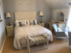 
a room with a bed, chair, lamp and a mirror at Thistle House Guest House in Saint Catherines
