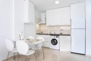 cocina blanca con mesa y electrodomésticos blancos en Apartamento Dulce Bea, en Puertito de Güímar