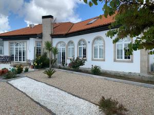 une maison blanche avec un toit rouge dans l'établissement Casa de Alpajares - Guest House & Spa, à Freixo de Espada à Cinta