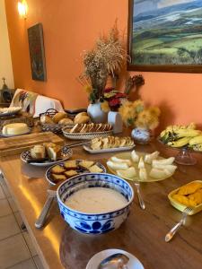 uma mesa com vários tipos diferentes de alimentos em Pousada Rosa dos Ventos em Delfinópolis