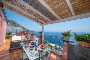a table on a balcony with a view of the ocean at Palazzo Rocco all 3 villas - Weddings in Praiano