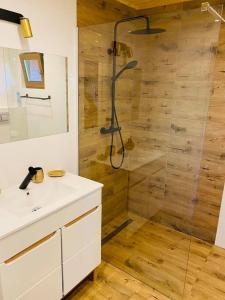 a bathroom with a shower and a white sink at Wierzbowa Dolina Mielno in Mielno