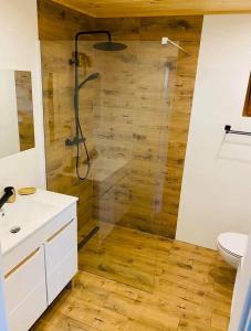 a bathroom with a shower with a wooden wall at Wierzbowa Dolina Mielno in Mielno +9 photos