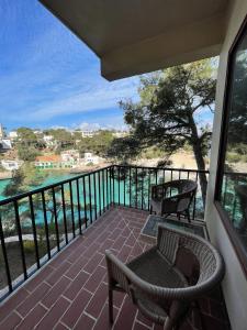 a balcony with chairs and a view of the water at Hostal Palmaria in Cala Santanyi