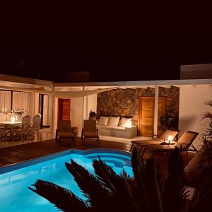 a villa with a swimming pool at night at Villa Shepherd Lajares - LUXURY VILLA FUERTEVENTURA in Lajares