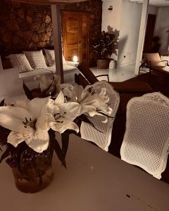 a vase of flowers on a table with two chairs at Villa Shepherd Lajares - LUXURY VILLA FUERTEVENTURA in Lajares
