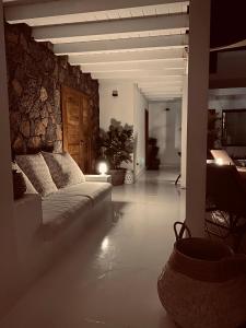 a living room with a couch and a stone wall at Villa Shepherd Lajares - LUXURY VILLA FUERTEVENTURA in Lajares