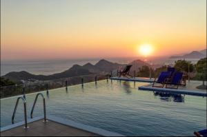 ein Pool mit Stühlen und der Sonnenuntergang im Hintergrund in der Unterkunft AparDibra in Bar