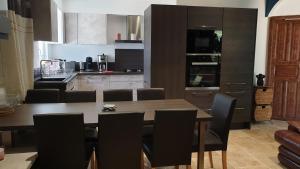 a kitchen with a wooden table and black chairs at JOLIE MAISON CONTEMPORAINE St Emilion in Néac