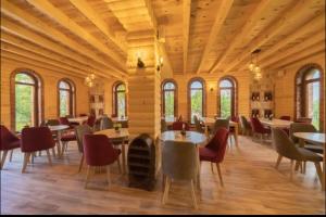 ein Esszimmer mit Tischen und Stühlen und Fenstern in der Unterkunft AparDibra in Bar