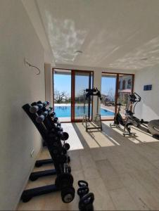 einen Fitnessraum mit mehreren Laufbändern und einem Pool in der Unterkunft AparDibra in Bar