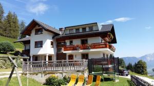 Uma casa com um monte de cadeiras à frente. em Kirchenbichlerhof em Pruggern