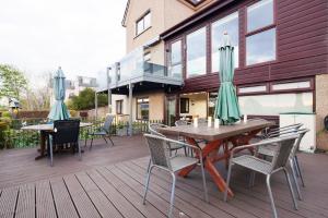 a wooden deck with tables and chairs and umbrellas at Ardentorrie Guest House in Inverness