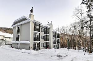 un edificio de apartamentos con nieve delante en 35#23 Chemin du Hameau, en Stoneham