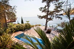 un complejo con piscina y vistas al agua en Villa VISTA LAGO, en Torri del Benaco