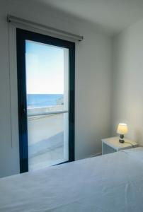 ein Schlafzimmer mit einem Fenster mit Blick auf das Meer in der Unterkunft CASA DAS TAIPAS in Vila Franca do Campo