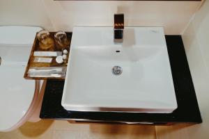 a white sink on a black counter in a bathroom at Lam Hồng Apartment & Hotel in Nha Trang