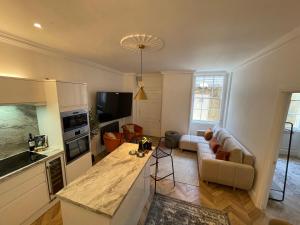 a kitchen and living room with a couch and a table at Central Period 2 Bed Apartment with Free Parking On Site Sleeps 1-6 in Bristol