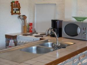 a kitchen with a sink and a microwave at Foyti in Dinant