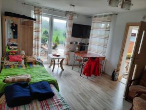 a bedroom with a bed and a kitchen with a table at Domek Pod Czubatką in Kawęczynek