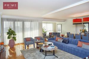 a living room with a blue couch and chairs at Prime Select Arkadia Nile View in Cairo