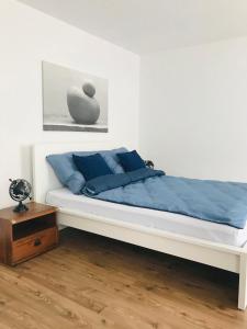 a bedroom with a white bed with blue pillows at Apartament Marina Mazury in Węgorzewo