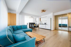 sala de estar con sofá azul y mesa en Panorama Views - Spacious Central Apartment, en Oradea