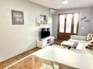 Una sala de estar con una mesa y sillas blancas. en Costa Esuri Golf y Playa V, en Ayamonte
