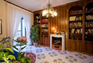 salon z kominkiem i żyrandolem w obiekcie DON VALERIO SORRENTO w Sorrento