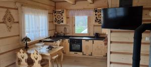 eine Küche mit einem Tisch und einem TV in einer Hütte in der Unterkunft Góralski Dom z pięknymi widokami na góry in Sosnowka