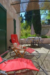 a patio with chairs and a table and an umbrella at Le Mas Sivan séjour arlésien 2 à 6 personnes wifi climatisation parking in Arles