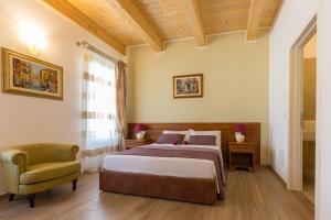 a bedroom with a bed and a chair at Villa Cavour in Comacchio