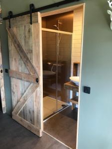 - une porte coulissante dans la salle de bains pourvue d'une douche dans l'établissement Landhaus KloosterStube, à Hermagor