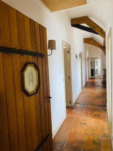 un couloir avec une porte en bois munie d'une horloge. dans l'établissement Maison des Arts Francueil, à Francueil