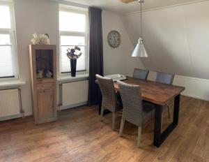 - une salle à manger avec une table et des chaises en bois dans l'établissement Kroonstuk 2, à Nes