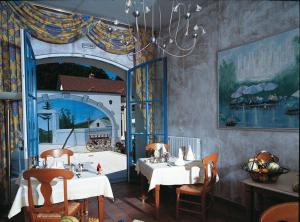 a dining room with two tables and a large window at Hotel Pinocchio in Gy