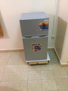 a refrigerator sitting on top of a tiled floor at Résidence Comara in Marcory