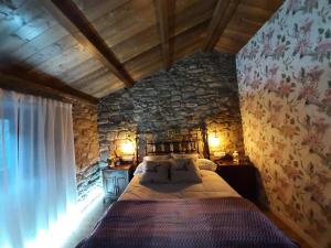 Un dormitorio con una cama y una pared de piedra. en Casa da Loura - Costa da Morte, en Dumbría 79 fotos más
