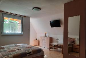 ザラカロシュにあるDóra Apartmanház Zalakarosのベッドルーム1室(ベッド1台、窓、ドレッサー付)