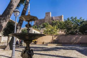 a stone fountain with a castle in the background at AIRAM Home ARAGON, 7 in Almansa
