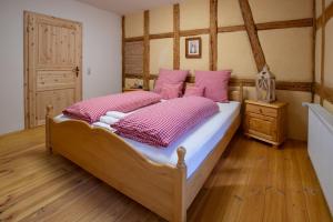 um quarto com uma cama grande e almofadas cor-de-rosa em Naturhof-Papiermühle 2 Bett-Zimmer Rosenrot em Bollberg