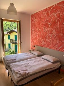 - une chambre dotée d'un lit avec un mur rouge dans l'établissement Hotel Garnì Delle Rose, à Dro