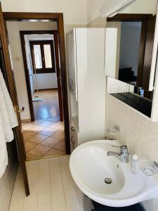 Appartamento Soldini في موركوت: حمام مع حوض أبيض ومرآة