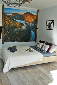 1 dormitorio con 1 cama y una gran pintura en la pared en łOWCA PIENIN en Szczawnica