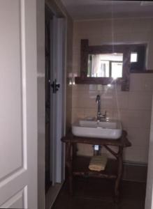 La salle de bains est pourvue d'un lavabo et d'une fenêtre. dans l'établissement Дом для отдыха в лесу, à Berëzovka
