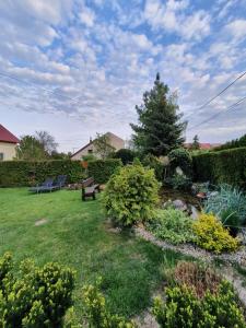 a garden with two chairs and a bench in a yard at Apartman Ilike in Balatonfüred