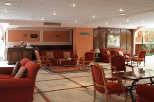 a waiting room with red chairs and tables at Hotel Begoña Park in Gijón