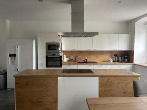 a kitchen with white cabinets and a wooden counter top at Ferienwohnung „Gmünder Hof“ in Gmünd