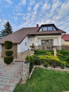a white house with a fence and a yard at Ilike Home in Balatonfüred