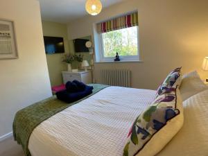 a bedroom with a bed and a window at The Little Boat House in Talsarnau